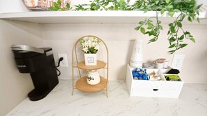 A kitchen with a coffee maker, a small shelf with a plant, and a storage unit with kitchenware. - 5 min walk to Notre Dame! Modern home (517) (South Bend)