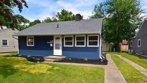 A single-story house with a front door, a small porch, and a well-maintained lawn. - 5 min walk to Notre Dame! Modern home (517) (South Bend)