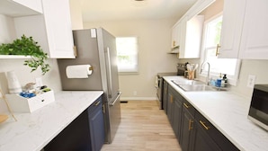 A modern kitchen with a refrigerator, sink, and cabinets. - 5 min walk to Notre Dame! Modern home (517) (South Bend)