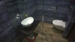 Een badkamer met een wit wastafel, toilet en spiegel.