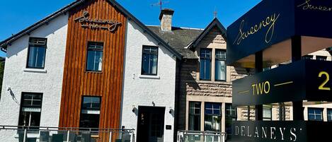 Un edificio de dos pisos con fachada de madera y un letrero que indica que es el restaurante Delaney's.