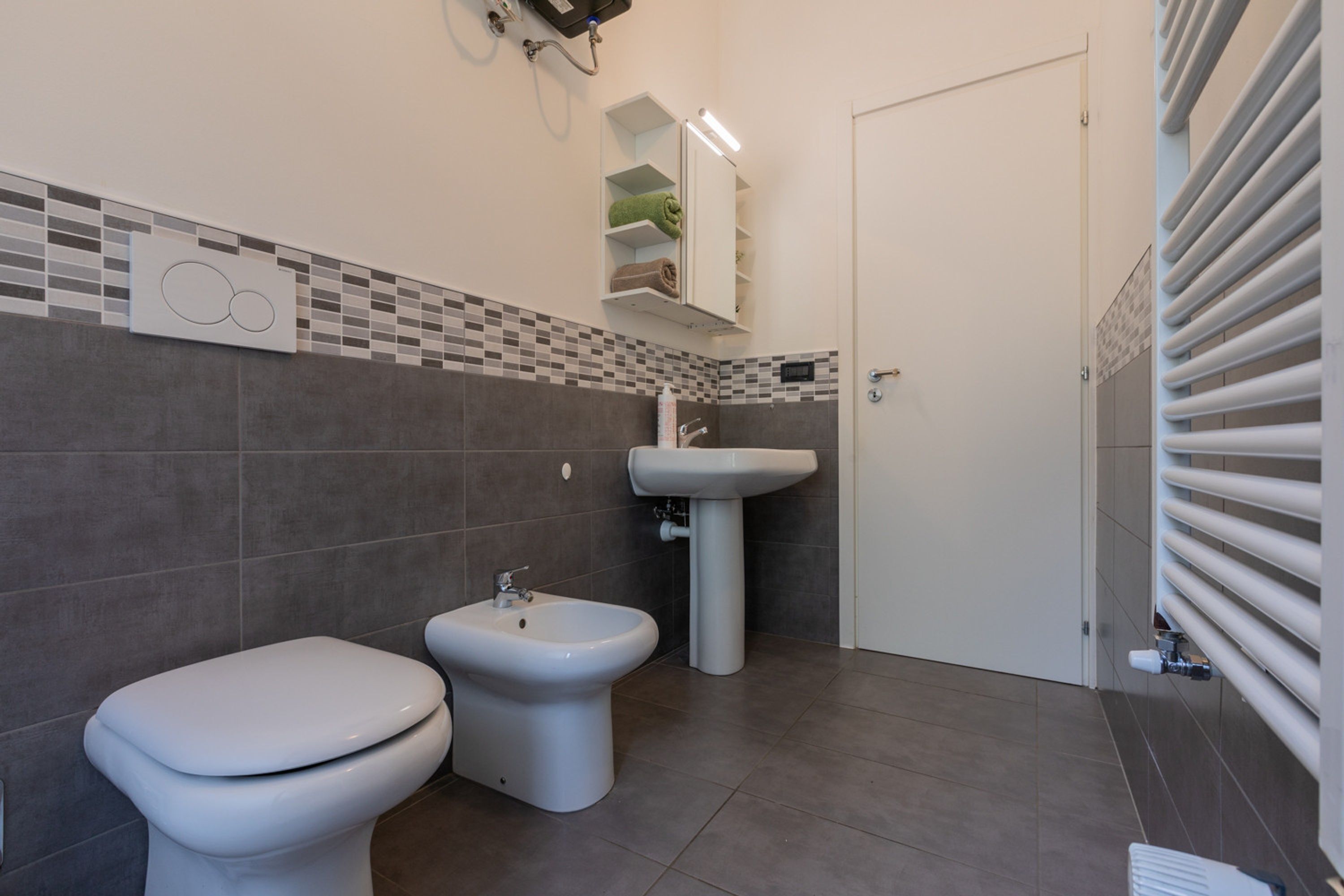 A modern bathroom with a toilet, bidet, and sink.