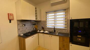 Habitación clásica, balcón, vista a la ciudad | Cocina privada | Microondas, horno, parrilla de estufa y utensilios de cocina