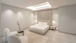 Un dormitorio moderno con una cama grande, un escritorio y una silla.