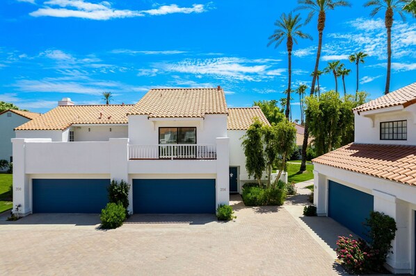 A modern two-story house with a tiled roof, a balcony, and a garage.
