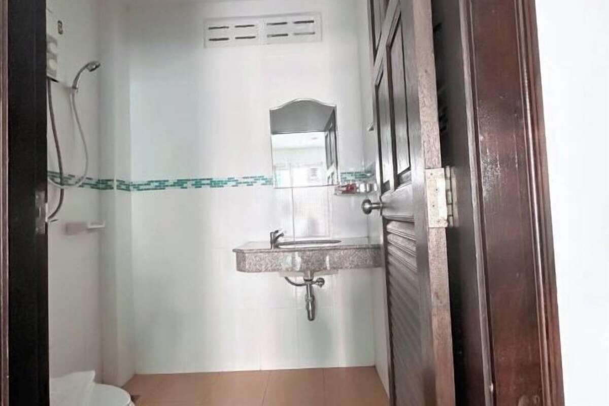 A bathroom with a sink, mirror, and shower.