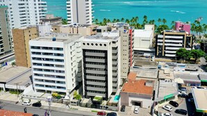 A high-rise building with multiple floors, a parking area, and a view of the ocean. - Top Unique Maceió  (Maceió)