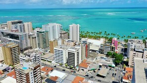 A coastal cityscape with high-rise buildings, a marina, and palm trees.