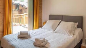 Une chambre à coucher avec un lit, des oreillers et une fenêtre avec des rideaux.