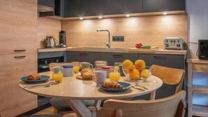 Une cuisine moderne avec une table de salle à manger ronde, des meubles de rangement en bois et un four encastré.