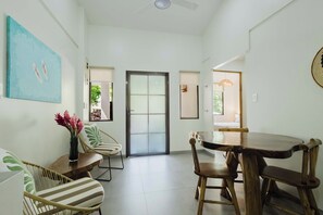 Una habitación amplia con una mesa de comedor, sillas y un ventanal grande.