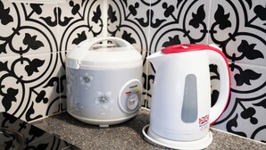 Una cocina con tostadora y hervidor sobre una encimera de granito.