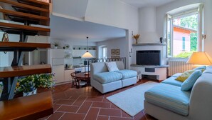 Una sala de estar moderna con un sofá, un comedor y una chimenea.