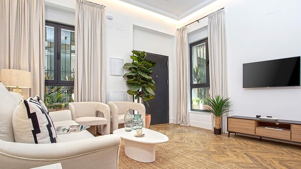 A modern living room with a sofa, coffee table, and TV. - Genteel Home Lagar II (Seville)