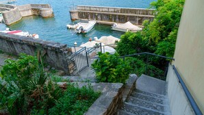 Escadas que levam a um cais com barcos.