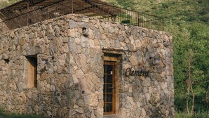 Un edificio de piedra con una puerta de madera y una barandilla de metal.