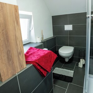 Regadera, secadora de cabello, toallas, papel de baño