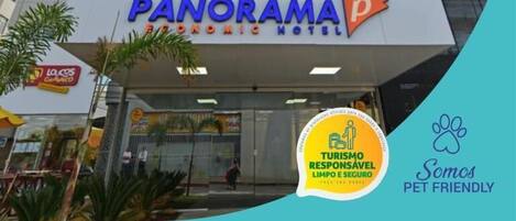 Un hotel de diseño moderno llamado "Panorama Economic Hotel", con un letrero llamativo y un logotipo que admite mascotas.