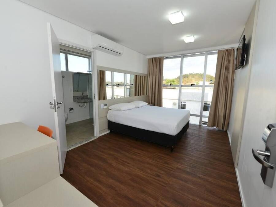 Ein Hotelzimmer mit einem Bett, einem Schreibtisch und Blick aus dem Fenster.