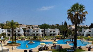 A resort with multiple swimming pools, palm trees, and white buildings with red-tiled roofs. - Casa Sophie Albufeira Apartment With 2 Bedrooms (Albufeira)