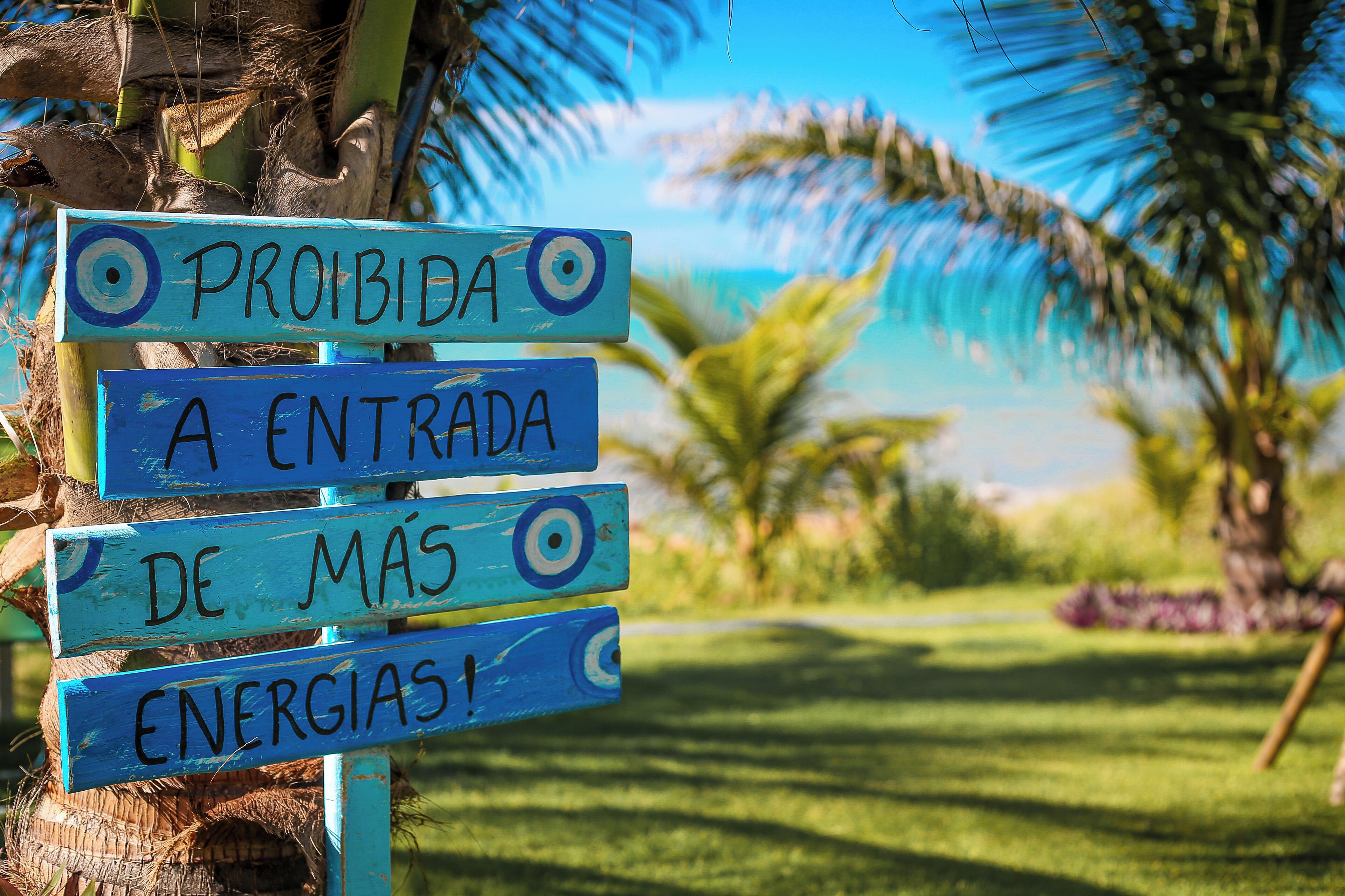 Una señal con el texto 'PROHIBIDA LA ENTRADA DE MÁS ENERGÍAS' en un entorno tropical.
