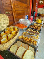 Un bufé con diversos alimentos, incluyendo pan, pasteles y frutas.