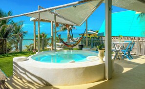 A circular pool with a white edge, surrounded by a wooden deck and a white canopy.