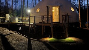 A dome-shaped yurt with a wooden deck and a staircase leading to the entrance. - Löyly Luxury Dome, Hot Tub, Sauna, Plunge, King, Queen, Kitchen, Sleeps 4, N. MI (Benzonia)