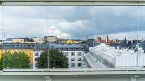 A view from a window overlooking a cityscape with various buildings, including a yellow building and a white building with multiple windows. - CentralStudio with Rooftop Terrace (Helsinki)
