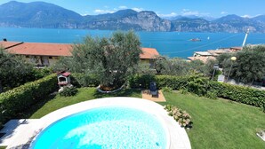A pool surrounded by a well-maintained garden, with a view of a lake and mountains in the background. - VILLA MIMOSA - Stunning lake view, private garden, swimming pool and Jacuzzi (Brenzone sul Garda)