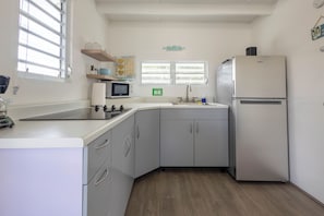 A compact kitchen with a microwave, sink, and refrigerator. - Villa Sol - Cabo Rojo - Perfect tiny house with WIFI (El caño)