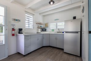 A kitchen with white cabinets, a refrigerator, a microwave, and a coffee maker. - Villa Sol - Cabo Rojo - Perfect tiny house with WIFI (El caño)