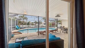 A pool area with lounge chairs and a covered seating area. - Waterfront Pool Home - 12PPL 4BR (Clearwater)