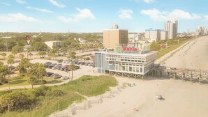 Un hôtel situé sur la côte, doté d’un bar sur le toit, d’un parking et offrant une vue sur la plage.