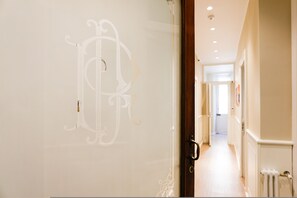 Un pasillo con un muro decorativo y una puerta con pomo de latón.