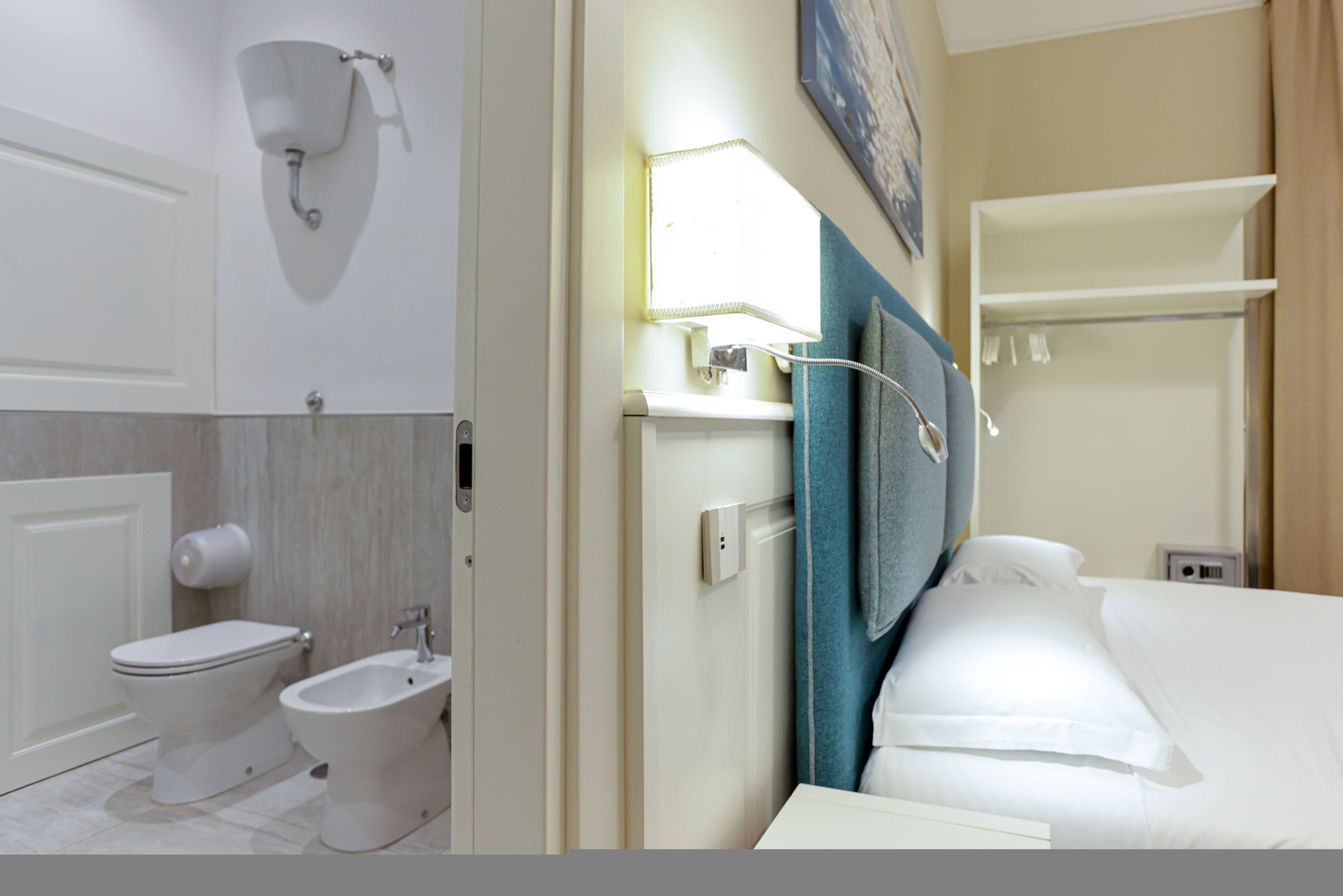 A hotel bathroom with a toilet, bidet, and towel rack.