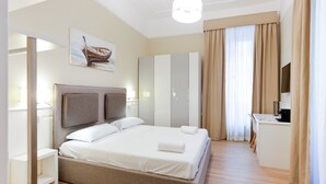 Une chambre d’hôtel moderne, dotée d’un grand lit, d’un bureau et d’une armoire.