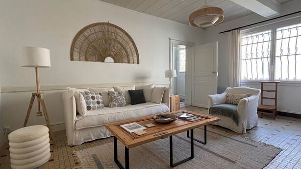 A living room with a sofa, a coffee table, a floor lamp, and a chair.