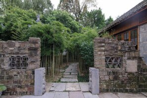 A traditional stone gate leading to a building with a tiled roof. - Xianting Inn (Liyang)