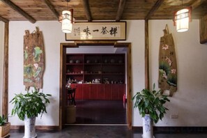 A traditional Japanese interior with a wooden ceiling, a reception desk, and a wall-mounted sign. - Xianting Inn (Liyang)