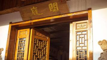 A traditional wooden door with intricate lattice patterns and a sign above it.