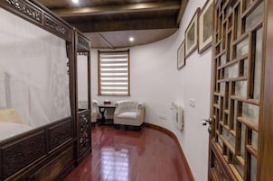 Un dormitorio con cama con dosel, una mesita y una silla.