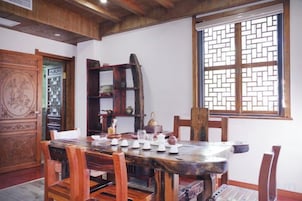 Comedor tradicional con una mesa de madera dispuesta para el té, rodeada de sillas.