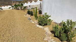 A garden with gravel paths, cacti, and a white wall with terracotta pots. - 3beds Villa w/ Pool - Near Almeria Beaches (Cantoria)