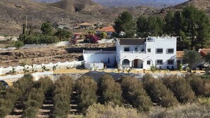 A white building with a balcony, surrounded by dry vegetation and mountains in the background. - 3beds Villa w/ Pool - Near Almeria Beaches (Cantoria)