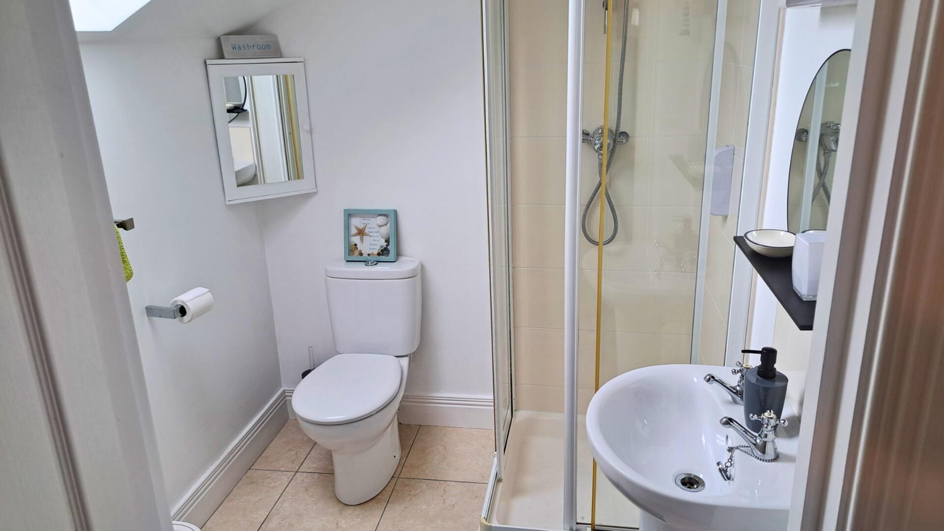 A bathroom with a toilet, a sink, and a shower enclosure.