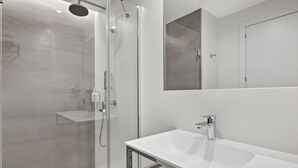 A modern bathroom with a glass-enclosed shower, a white sink, and a large mirror above the sink. - B&B Hotel Madrid Tres Cantos  (Tres Cantos)