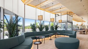 A modern interior with a curved seating area, large windows, and a wooden ceiling. - B&B Hotel Madrid Tres Cantos  (Tres Cantos)