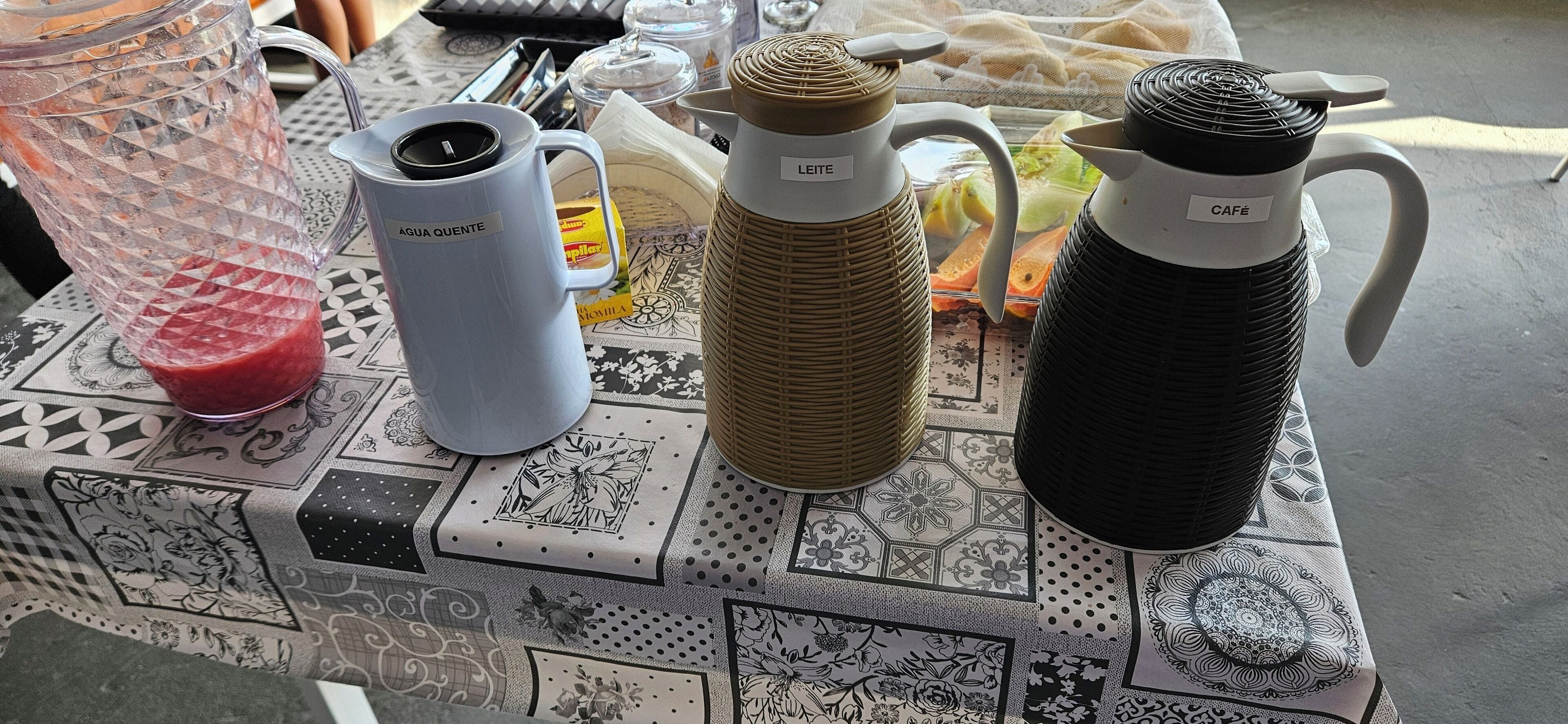 A table with a variety of kitchenware including a blender, a white mug, and two insulated water bottles.