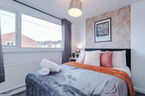 Relax in comfort with a large bed, a stylish headboard, and a cozy nightstand.